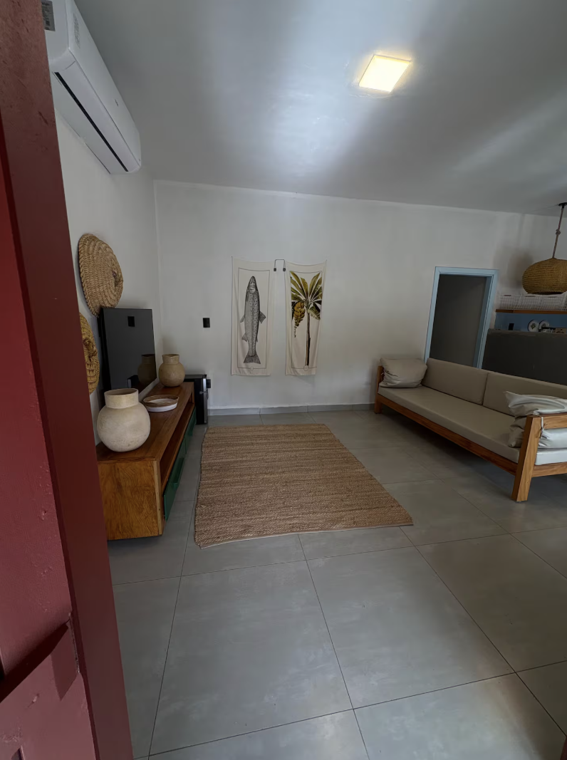 Sala ampla com tapete de fibra e quadros decorativos