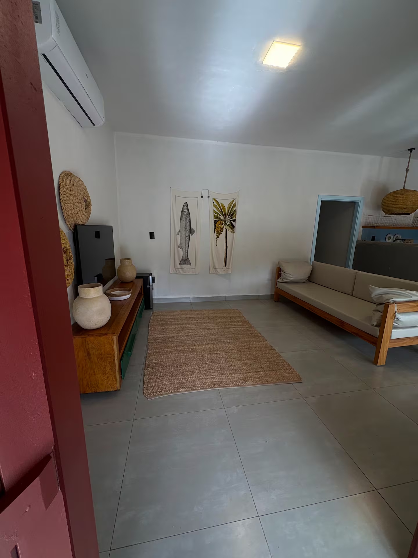 Sala de estar ampla com sofá de madeira e decoração rústica
