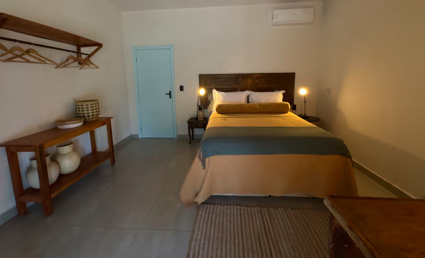 Suíte ampla com cama de casal e decoração rústica