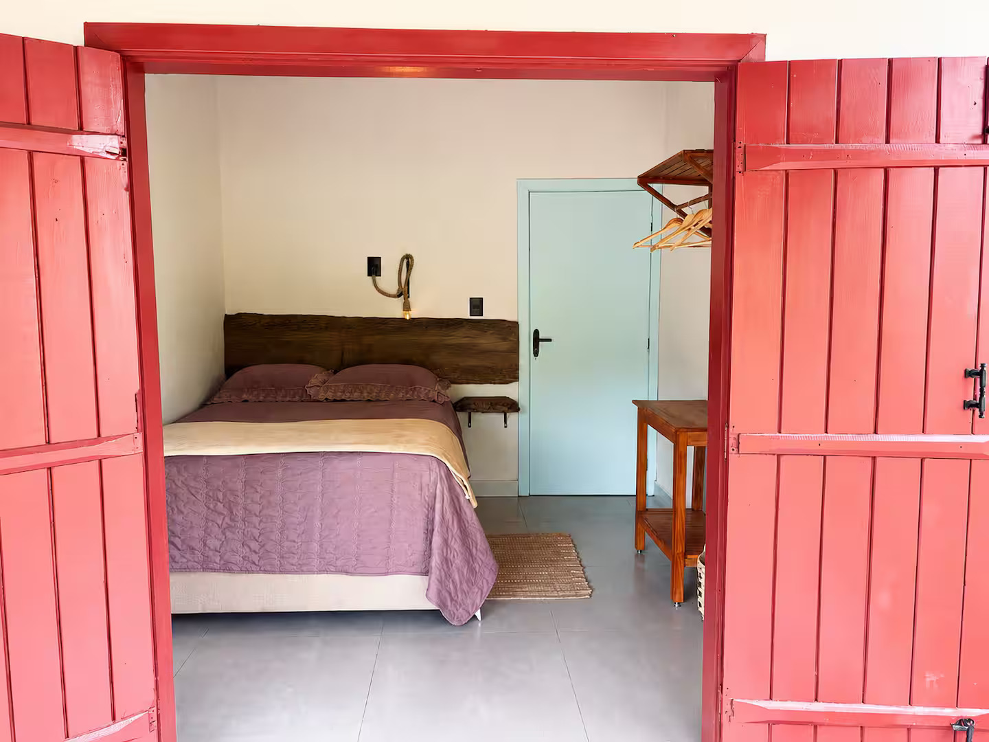 Quarto com portas vermelhas e cama de casal